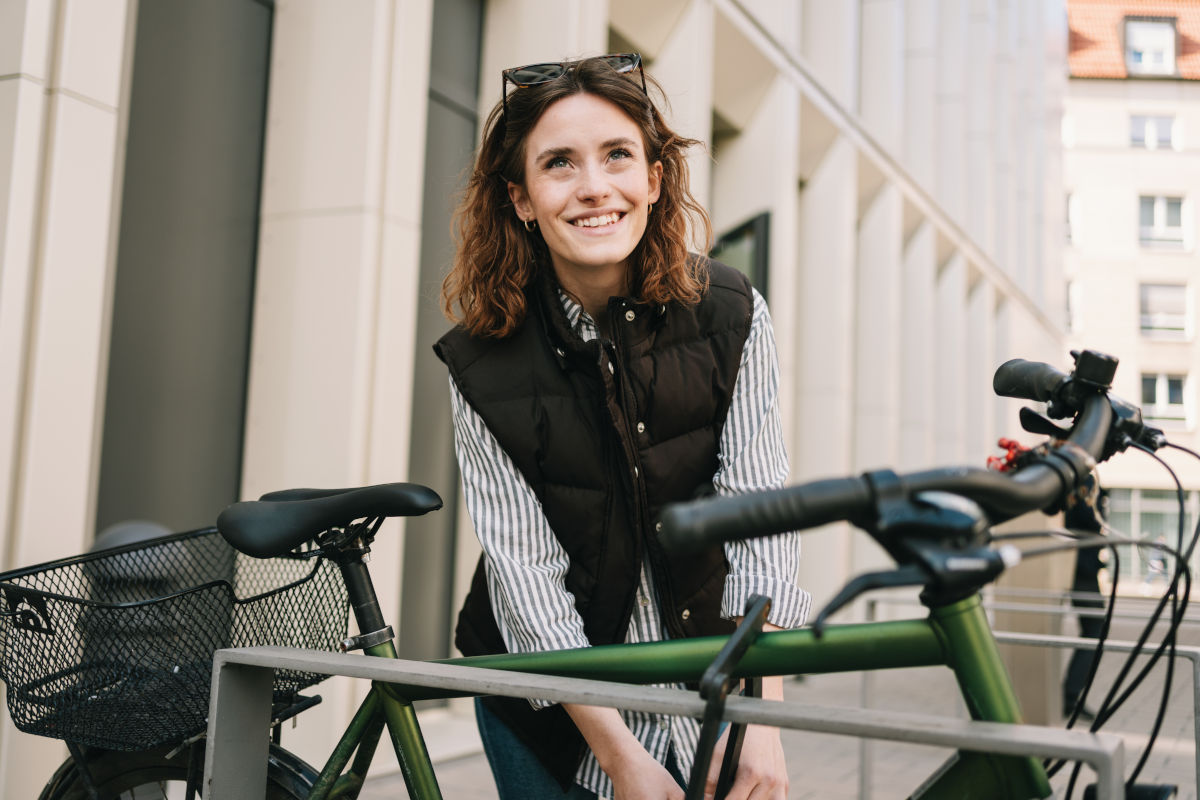 Lächelnde Frau sperrt ihr Fahrrad ab